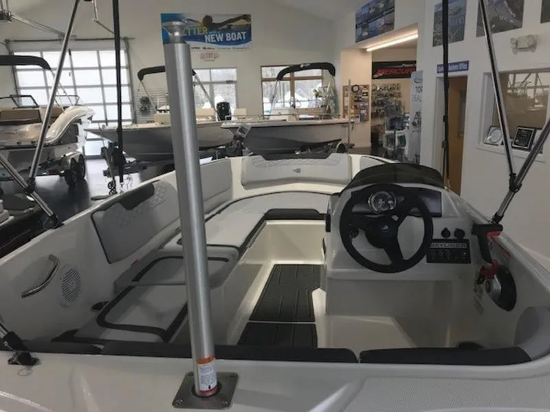 Slide: The Image of Interior view of a 2025 Bayliner M15 boat in a showroom. - 13