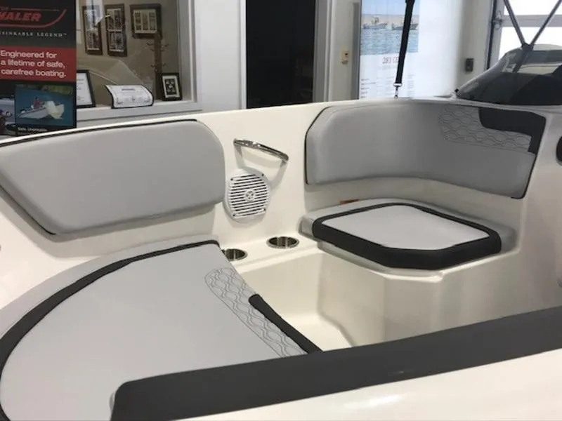 Slide: The Image of Interior of 2025 Bayliner M15 boat with cushioned seating and cup holders. - 7