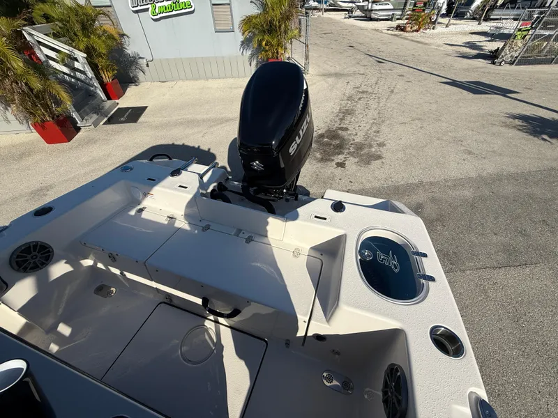 Slide: The Image of 2025 Sea Chaser 22 HFC boat with Suzuki outboard motor, docked in a sunny marina. - 11