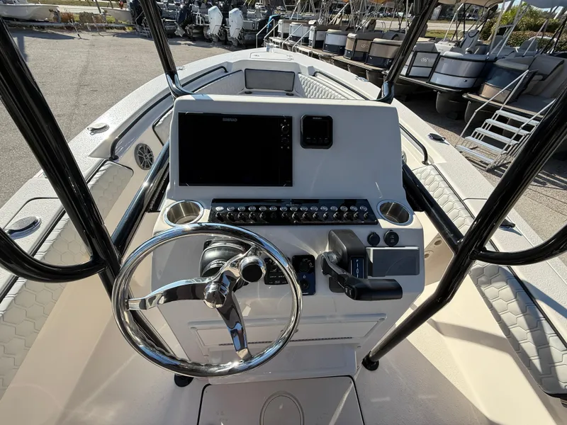 Slide: The Image of 2025 Sea Chaser 22 HFC boat console with steering wheel and navigation controls. - 13