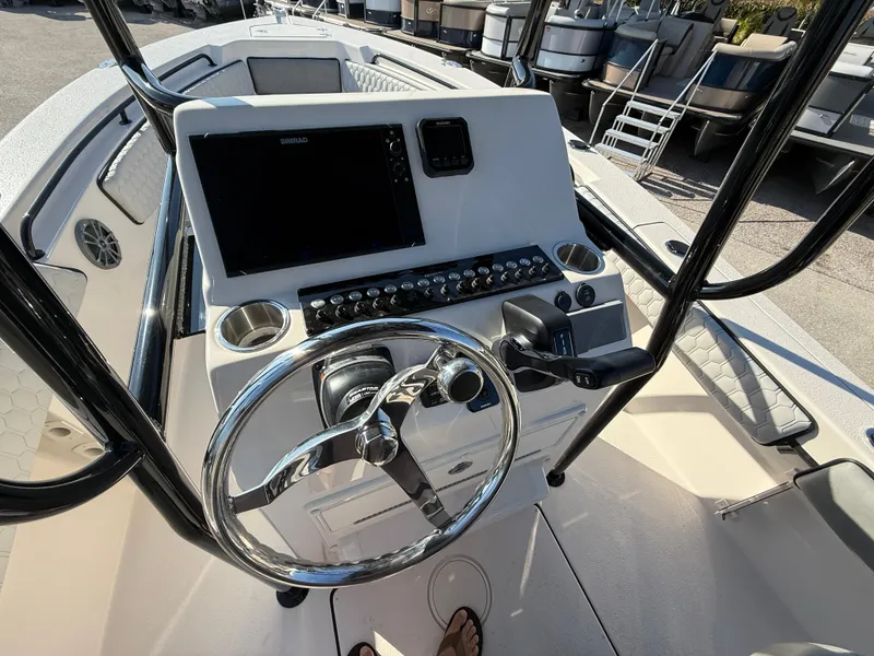 Slide: The Image of 2025 Sea Chaser 22 HFC boat console with steering wheel and navigation controls. - 14