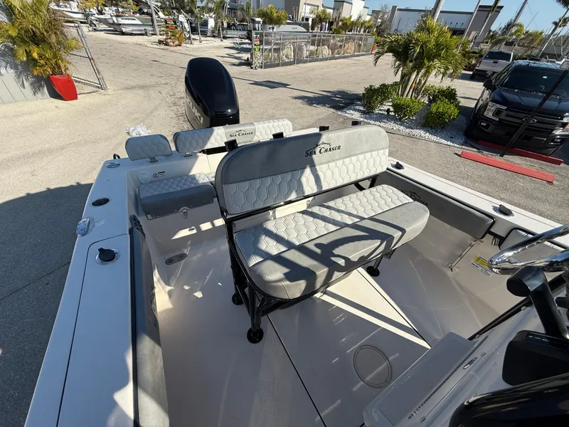Slide: The Image of 2025 Sea Chaser 22 HFC boat interior with seating and motor, docked outdoors. - 31