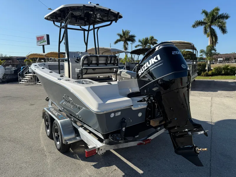 Slide: The Image of 2025 Sea Chaser 22 HFC boat with Suzuki engine on trailer, parked outdoors. - 9