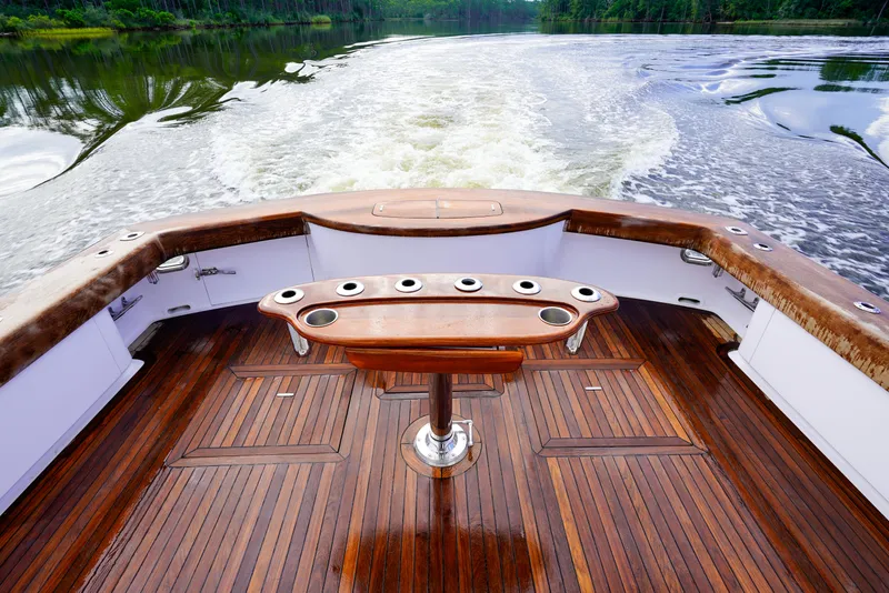 Slide: The Image of Custom Carolina 45 F&S 2008 boat with wooden deck and rod holders on a serene waterway. - 21