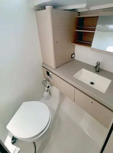Slide: The Image of Modern bathroom in 2022 Beneteau Oceanis 51.1 yacht with sink, toilet, and storage. - 21