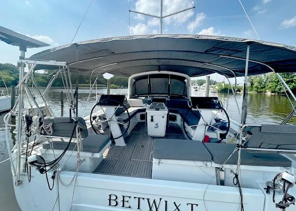 Slide: The Image of 2022 Beneteau Oceanis 51.1 sailboat docked, featuring dual steering wheels and spacious cockpit. - 3