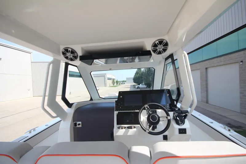 Slide: The Image of 2026 Zodiac X10CC boat with beige seating and joystick control, docked near industrial buildings. - 20