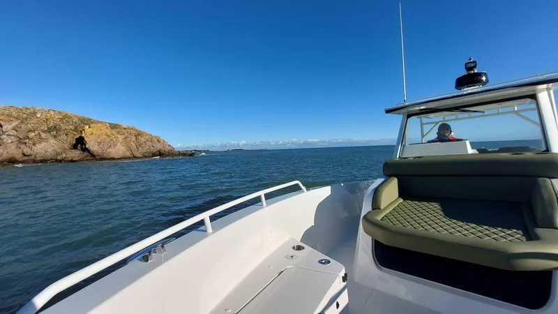 Slide: The Image of Zodiac X10CC boat cruising near rocky coastline under clear blue sky, 2025 model. - 10