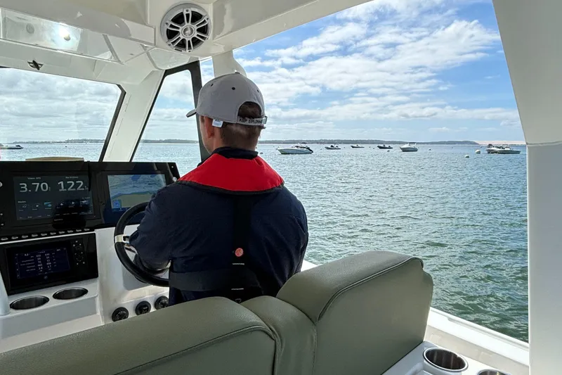 Slide: The Image of Person steering 2025 Zodiac X10CC boat with Twin Yamaha 450 engines on open water. - 14