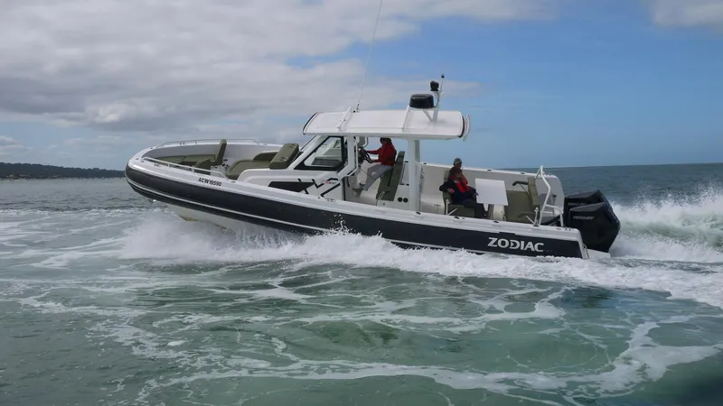 Slide: The Image of 2025 Zodiac X10CC boat with twin Yamaha 450 engines navigating ocean waves. - 2