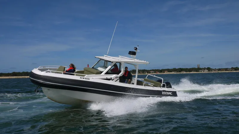 Slide: The Image of 2025 Zodiac X10CC boat with twin Yamaha 450 engines cruising on water. - 4