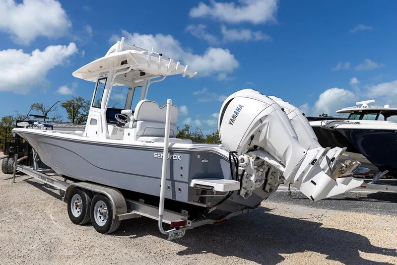Slide: The Image of 2025 Sea Fox 282 Hybrid LT boat on trailer with Yamaha engine, parked outdoors. - 2