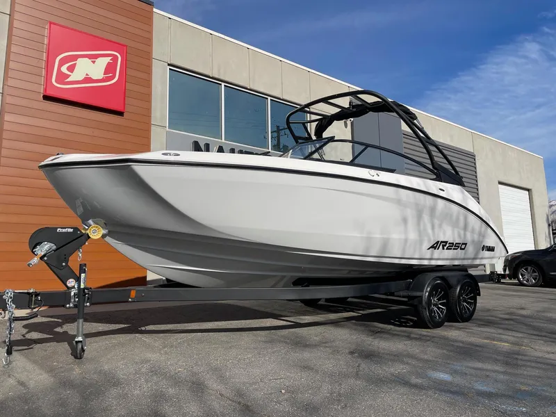 Slide: The Image of 2025 Yamaha Boats AR250 on trailer outside dealership. - 2