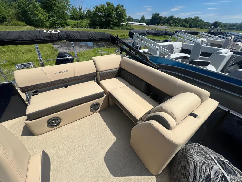 Slide: The Image of 2024 Harris Sunliner 230 boat interior with beige seating and speakers. - 12