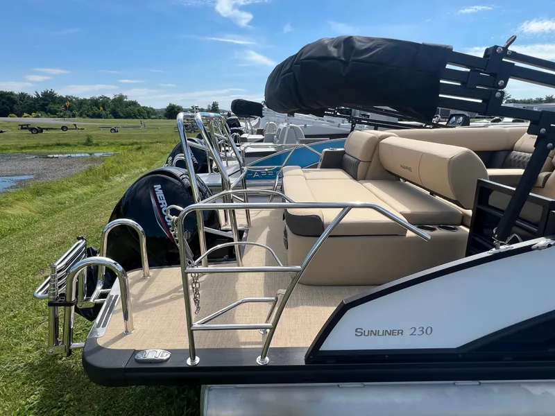 Slide: The Image of 2024 Harris Sunliner 230 pontoon boat with plush seating and sleek design. - 5