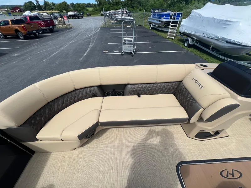 Slide: The Image of 2024 Harris Sunliner 230 boat interior with beige seating in a parking lot. - 8