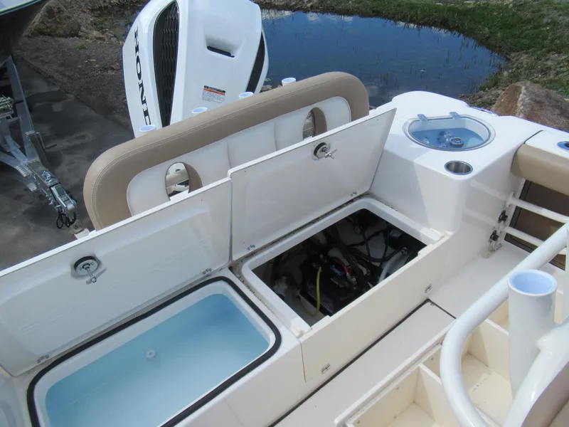 Slide: The Image of 2025 Sea Born LX24 Center Console boat with open storage compartments and Honda engine. - 11