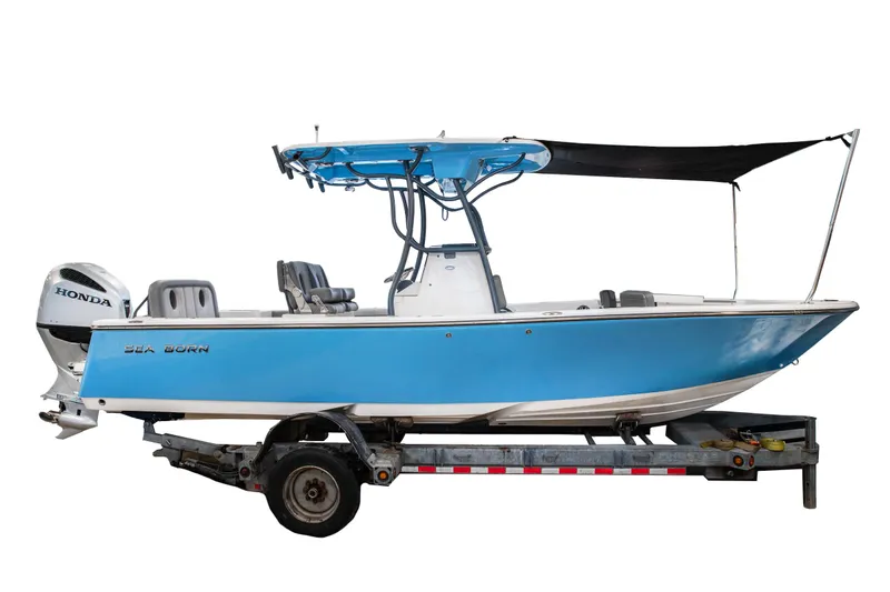 Slide: The Image of 2025 Sea Born LX24 Center Console boat on trailer, blue hull, Honda outboard motor. - 2