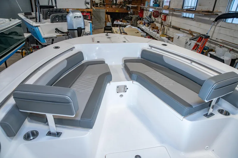 Slide: The Image of 2025 Sea Born LX24 Center Console boat interior with gray seating in a workshop. - 27