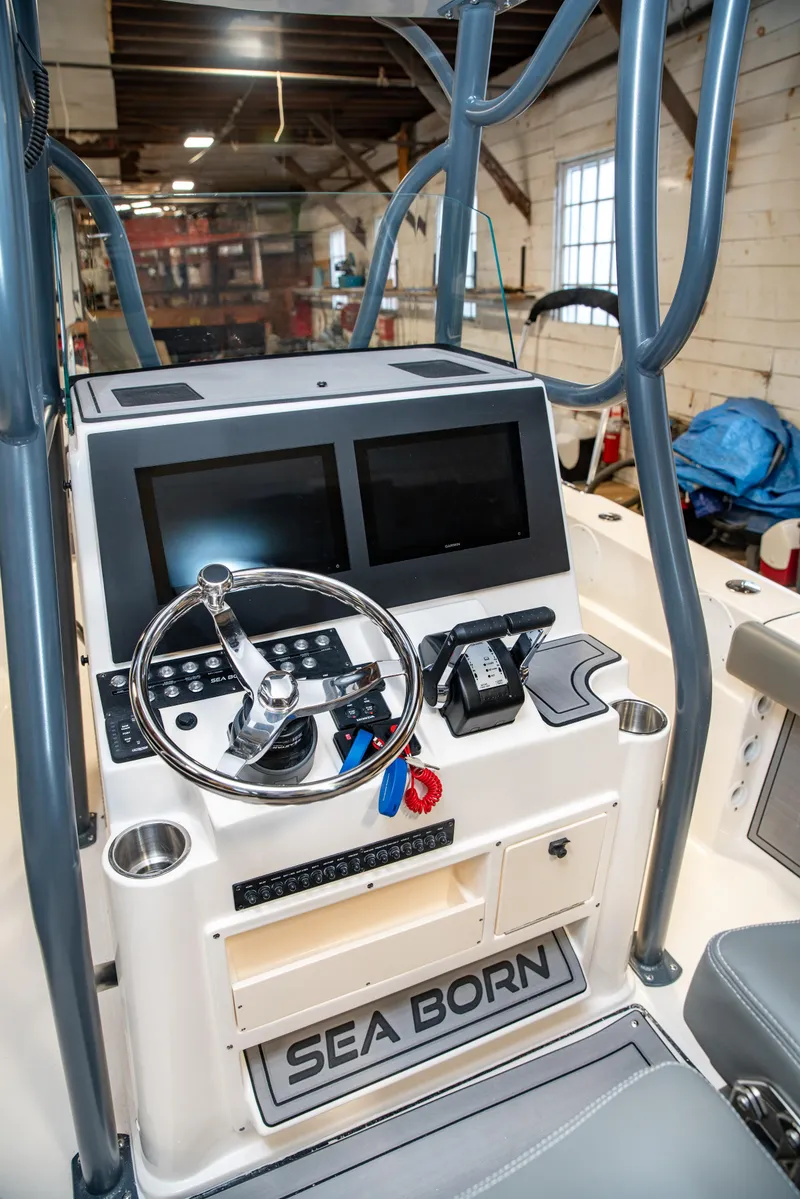 Slide: The Image of 2025 Sea Born LX24 Center Console boat interior with dual screens and steering wheel. - 34