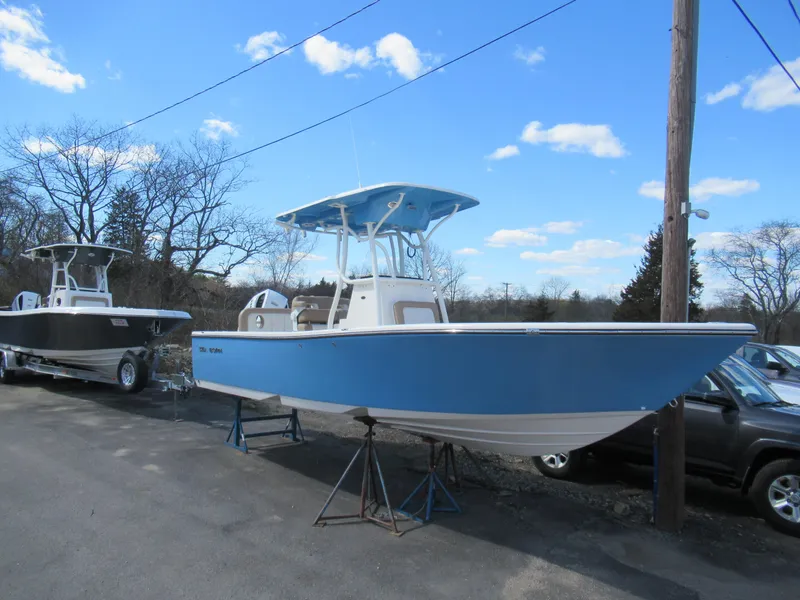 Slide: The Image of 2025 Sea Born LX24 Center Console boat in blue, parked outdoors on a sunny day. - 7