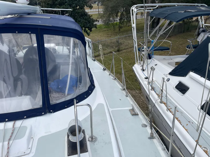 Slide: The Image of 1985 Gulfstar 45 Hirsch Center Cockpit sailboat with blue canopy, docked beside another boat. - 10