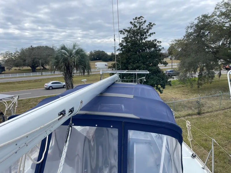 Slide: The Image of 1985 Gulfstar 45 Hirsch Center Cockpit sailboat with blue canopy, docked near a road. - 11