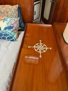 Slide: The Image of 1985 Gulfstar 45 Hirsch Center Cockpit interior with compass rose design on wooden surface. - 18