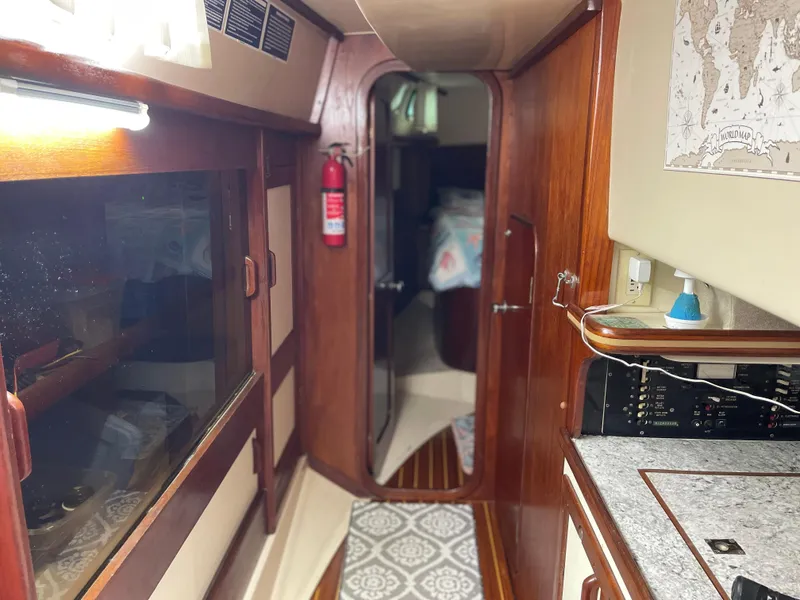 Slide: The Image of Interior of 1985 Gulfstar 45 Hirsch Center Cockpit, featuring wood paneling and nautical decor. - 25