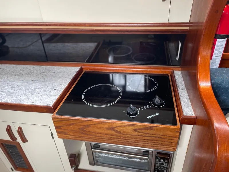 Slide: The Image of 1985 Gulfstar 45 Hirsch Center Cockpit kitchen with electric stove and wooden cabinetry. - 33