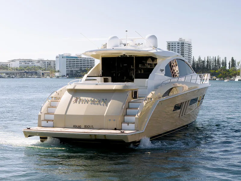 Slide: The Image of 2013 Lazzara LSX yacht cruising near modern waterfront buildings. - 12