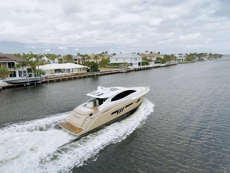 Slide: The Image of Luxury 2013 Lazzara LSX yacht cruising along a scenic waterfront with elegant homes. - 13