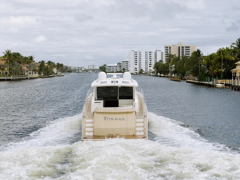 Slide: The Image of 2013 Lazzara LSX yacht cruising through a scenic canal with palm trees and buildings. - 14