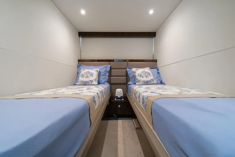 Slide: The Image of Twin beds in a 2013 Lazzara LSX yacht cabin with blue bedding and floral pillows. - 42