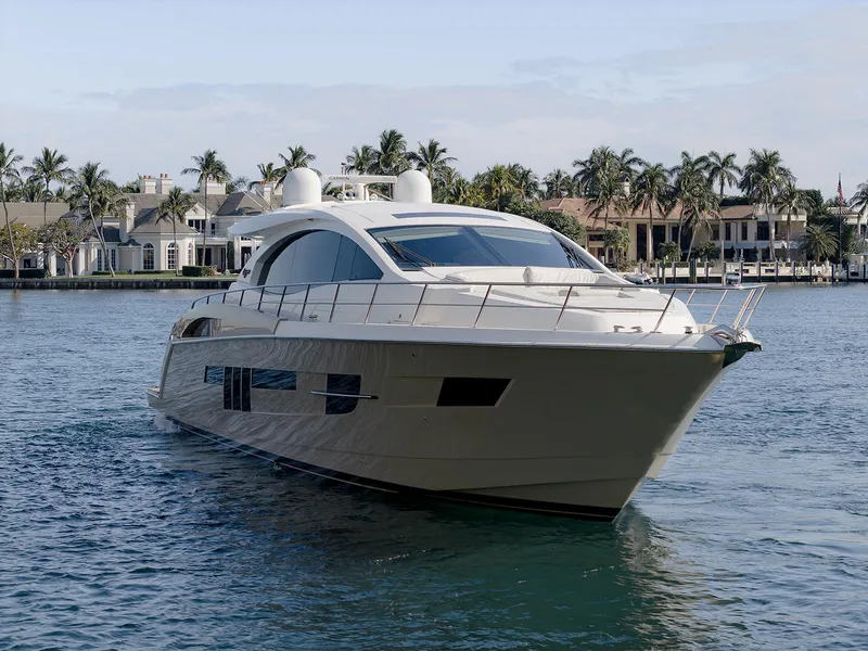 Slide: The Image of 2013 Lazzara LSX yacht cruising on a serene waterfront with palm trees. - 5
