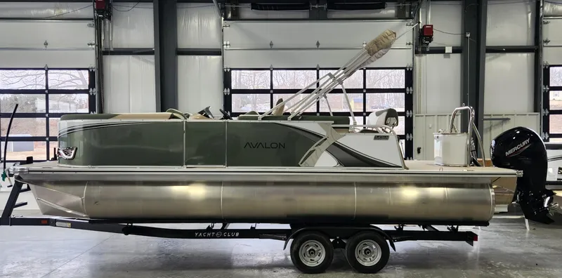 Slide: The Image of 2025 Avalon Platinum LSZ 2185 Cruise Rear Bench pontoon boat on trailer in garage. - 1