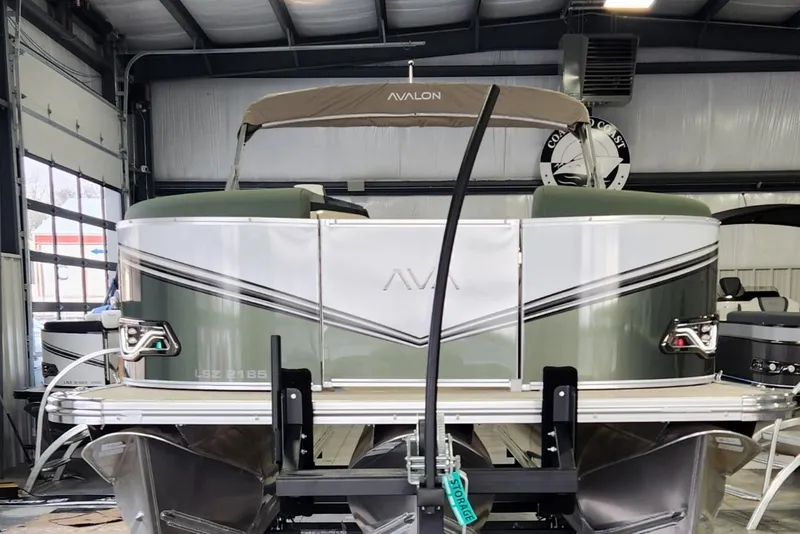 Slide: The Image of 2025 Avalon Platinum LSZ 2185 Cruise Rear Bench pontoon boat in a garage setting. - 2