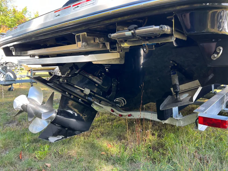 Slide: The Image of 2022 Sea Ray SLX 250 boat stern with propeller and outdrive on grass. - 19