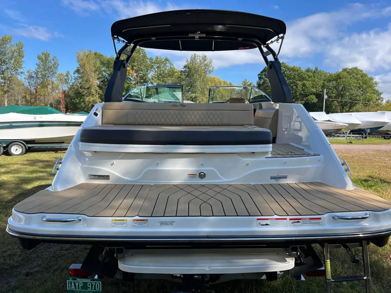 Slide: The Image of 2022 Sea Ray SLX 250 boat with spacious deck and seating, parked outdoors. - 25