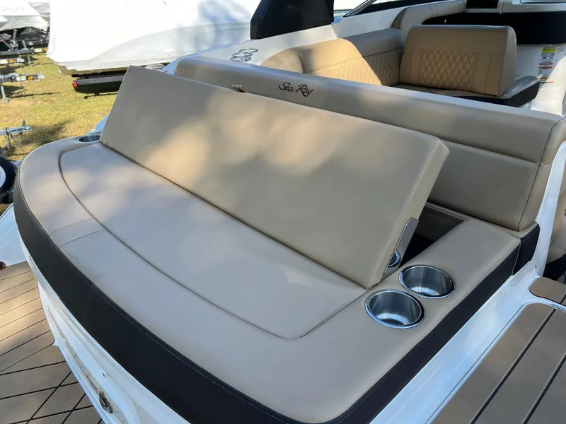 Slide: The Image of 2022 Sea Ray SLX 250 boat seating area with cup holders and beige upholstery. - 28