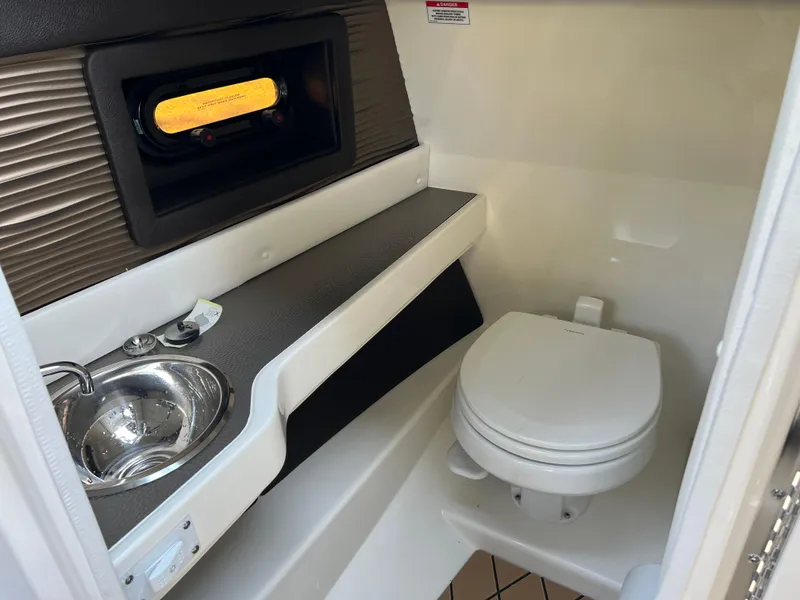 Slide: The Image of 2022 Sea Ray SLX 250 boat interior bathroom with sink and toilet. - 40