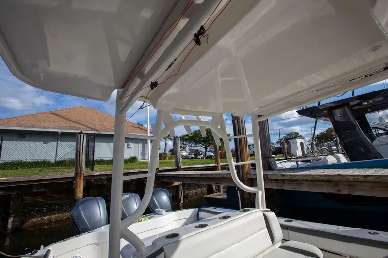 Slide: The Image of 2015 Yellowfin 39 Offshore boat interior, featuring seating and outboard motors at a dock. - 13