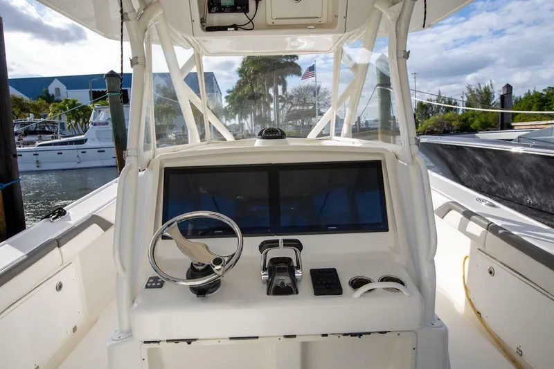 Slide: The Image of 2015 Yellowfin 39 Offshore boat cockpit with steering wheel and controls. - 15