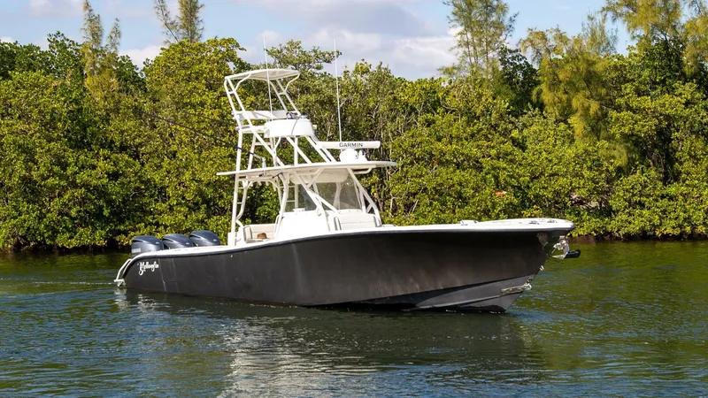 Slide: The Image of 2015 Yellowfin 39 Offshore boat on calm water near lush greenery. - 4