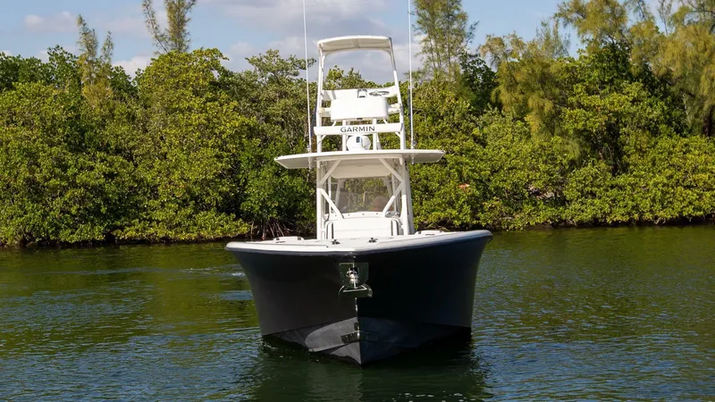 Slide: The Image of 2015 Yellowfin 39 Offshore boat on calm water, surrounded by lush greenery. - 5