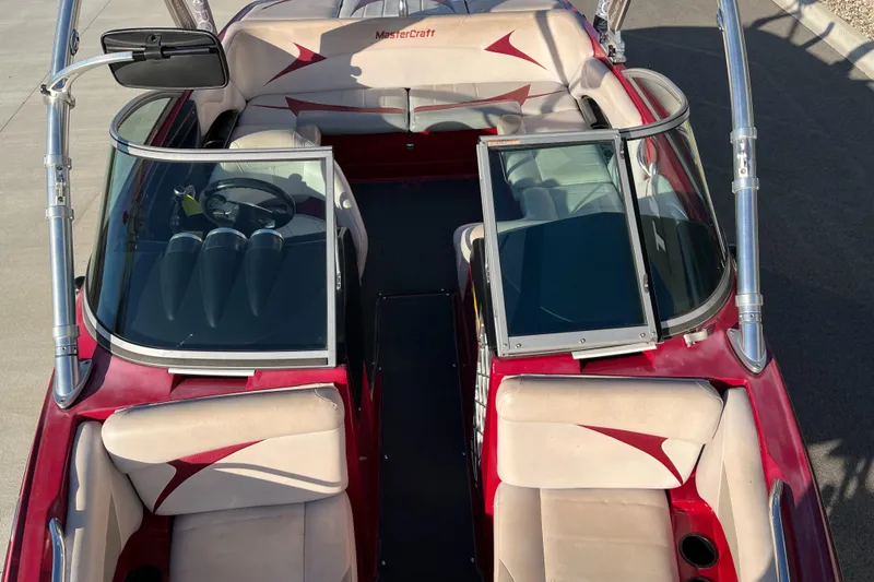 Slide: The Image of 2007 MasterCraft X2 boat interior with red and beige seating, open windshield, and steering wheel. - 13