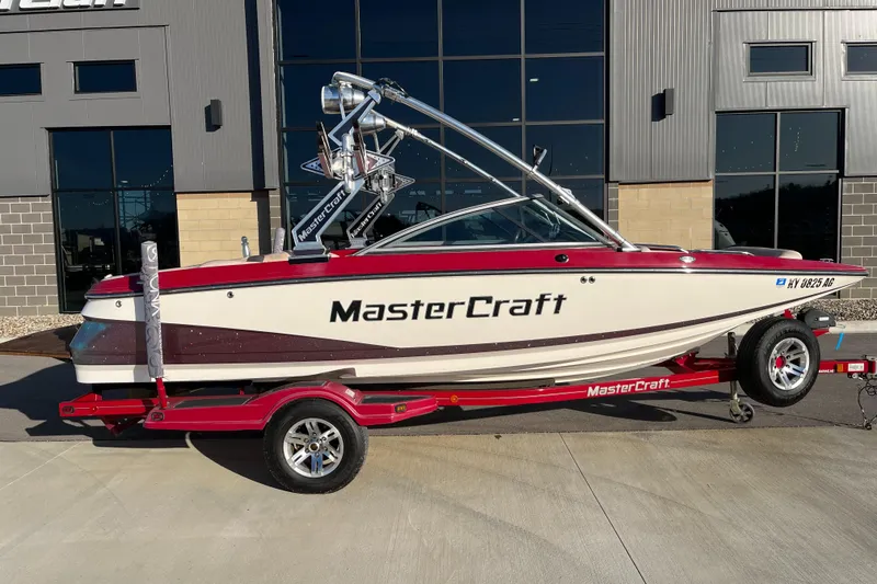 Slide: The Image of 2007 MasterCraft X2 boat on trailer, parked outside a building. - 2