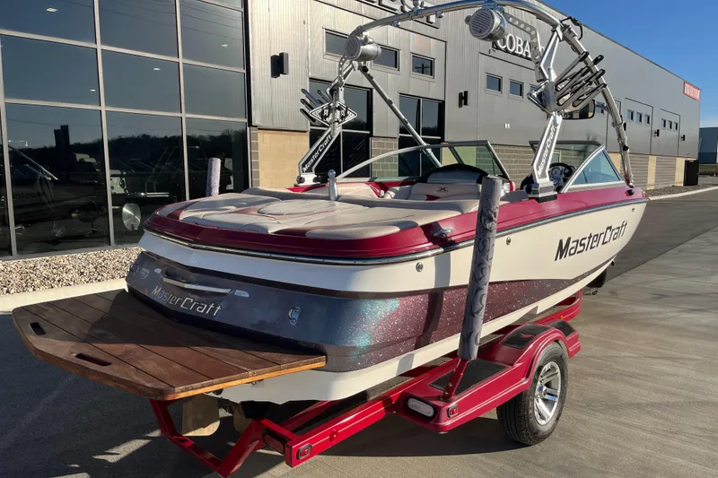 Slide: The Image of 2007 MasterCraft X2 boat on trailer, parked outside a modern building. - 3