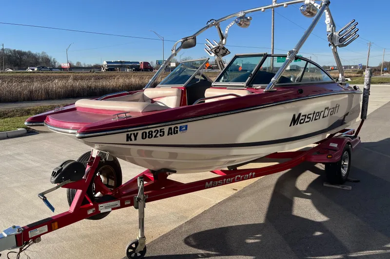 Slide: The Image of 2007 MasterCraft X2 boat on trailer, red and white design, parked outdoors. - 4
