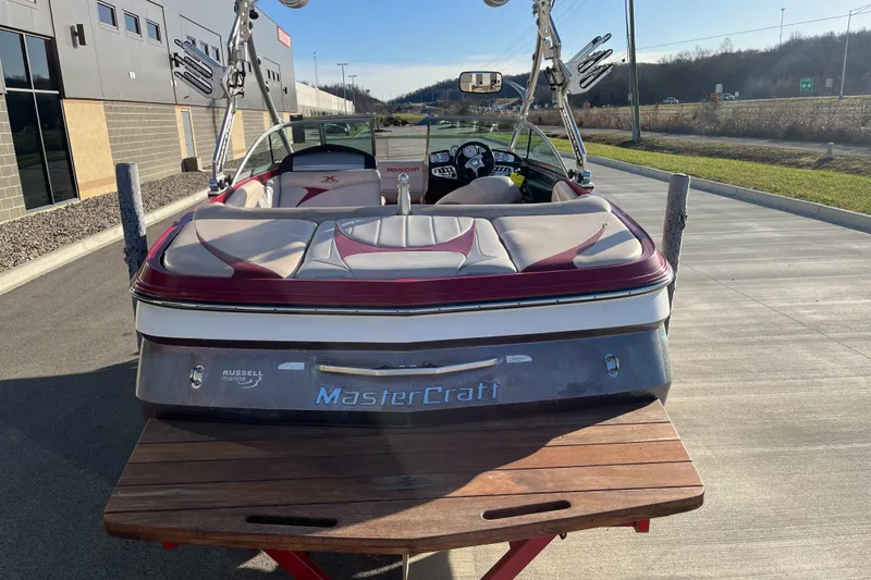 Slide: The Image of 2007 MasterCraft X2 boat with red and white interior, parked outdoors. - 8